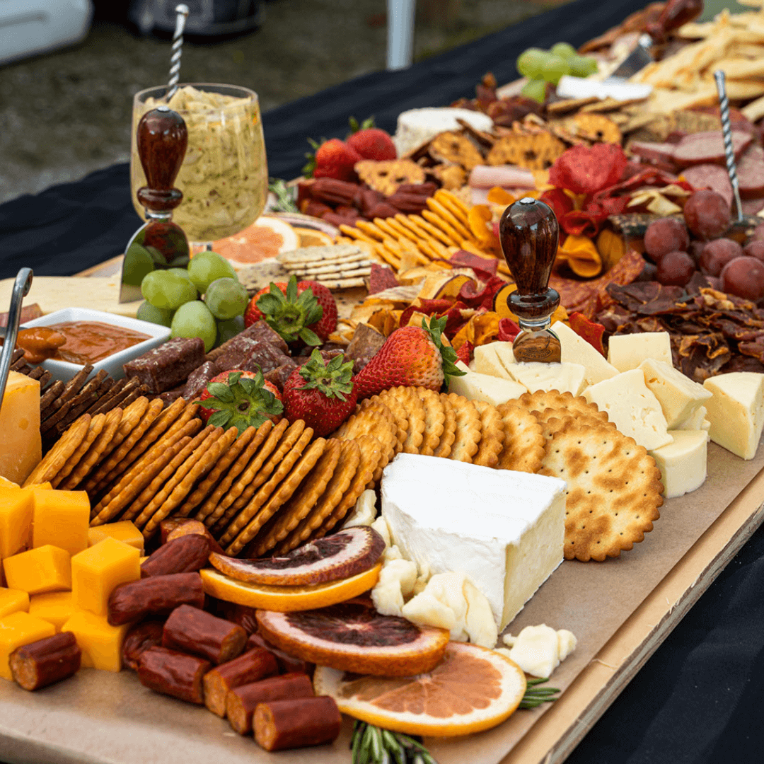 Grazing table with cheeses, charcuterie, fruit, and crackers